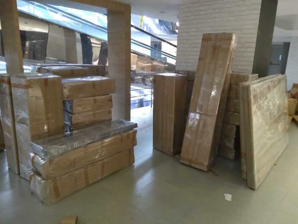 Multiple large items professionally wrapped and ready for transport in a modern lobby