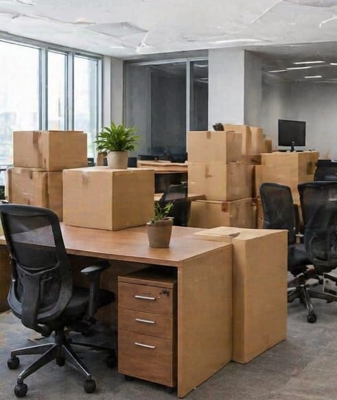 Office space with desks, chairs, and stacked cartons during a business office shift